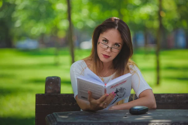 소녀는 공원에서 읽는 책 — 스톡 사진