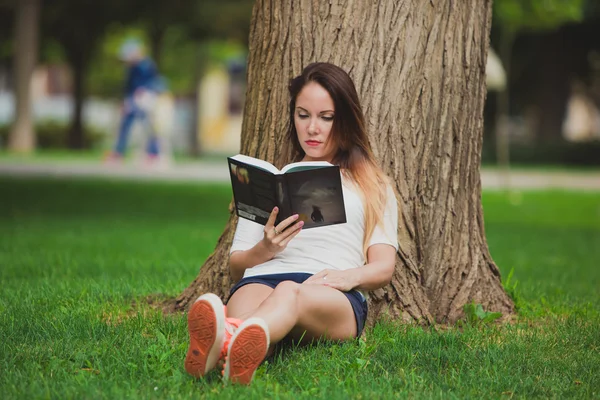 Κορίτσι με το βιβλίο κάτω από δέντρο — Φωτογραφία Αρχείου