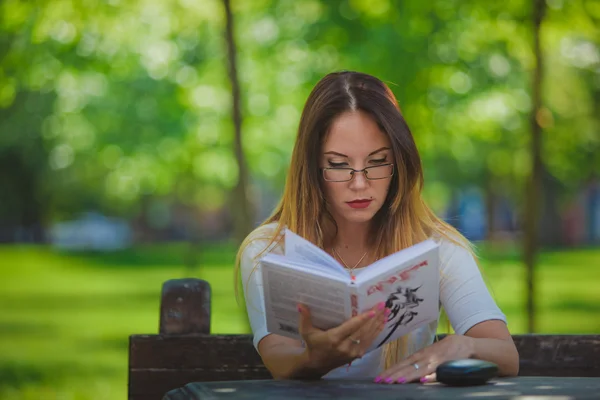 Mädchen mit Buchlesung im Park — Stockfoto