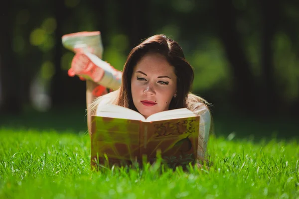 Mädchen mit Buch auf dem Gras — Stockfoto