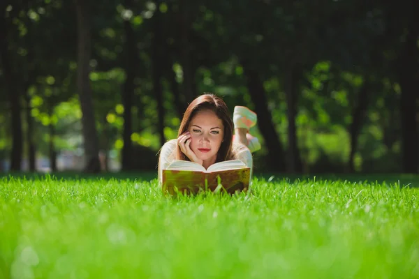 Mädchen mit Buch auf dem Gras — Stockfoto