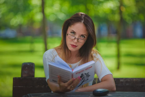 Mädchen mit Buchlesung im Park — Stockfoto