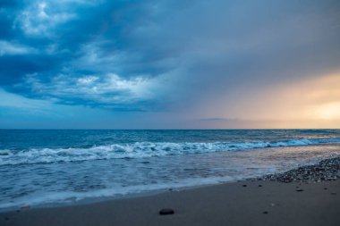 Deniz kıyıları gün batımında taşlarla