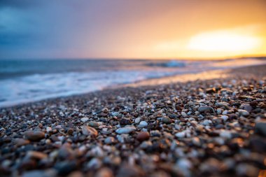 Deniz kıyıları gün batımında taşlarla