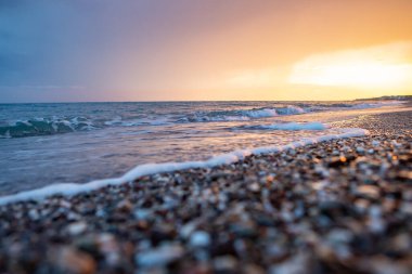Deniz kıyıları gün batımında taşlarla