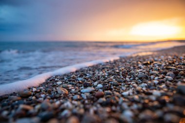 Deniz kıyıları gün batımında taşlarla