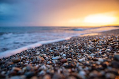 Deniz kıyıları gün batımında taşlarla