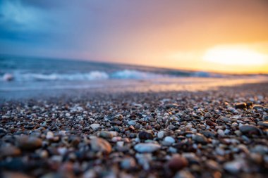 Deniz kıyıları gün batımında taşlarla