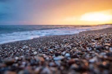 Deniz kıyıları gün batımında taşlarla