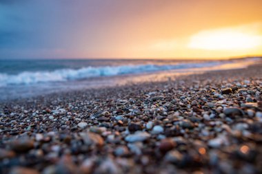 Deniz kıyıları gün batımında taşlarla