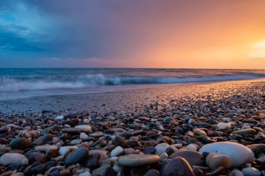 Deniz kıyıları gün batımında taşlarla