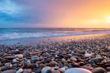 Deniz kıyıları gün batımında taşlarla