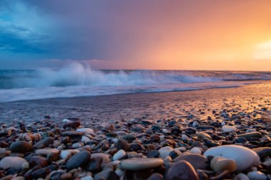 Deniz kıyıları gün batımında taşlarla