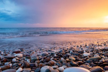 Deniz kıyıları gün batımında taşlarla
