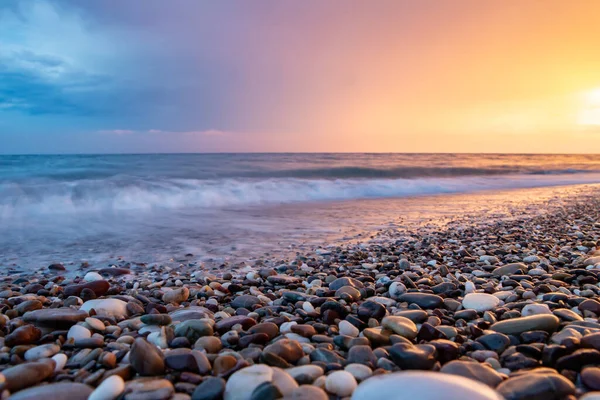 Deniz kıyıları gün batımında taşlarla