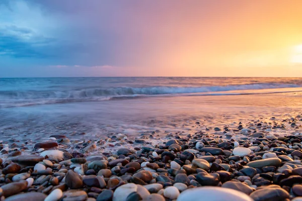 Deniz kıyıları gün batımında taşlarla