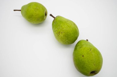 Beyaz arka plandaki bir stantta taze armutlar.