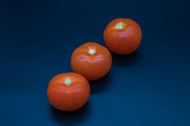 Domatesler koyu arkaplanda büyük ve küçük.