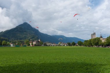 Interlaken, İsviçre - 10 Ağustos 2019 - Alplerin arka planında Interlaken 'de paraşütle atlama