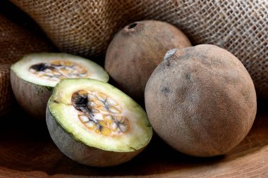 Dahi ya da ardıç meyvesi likörler ve ahşap bir masa üzerindeki tatlılar ve arka plandaki kırsal kumaş için iyidir.