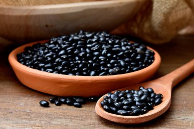 black beans in wooden bowl on the wood background