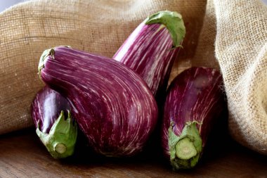 Tahta masada taze organik patlıcanlar.