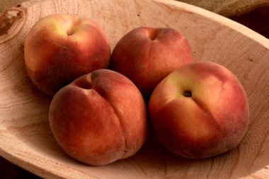 Tahta bir masada olgun şeftaliler