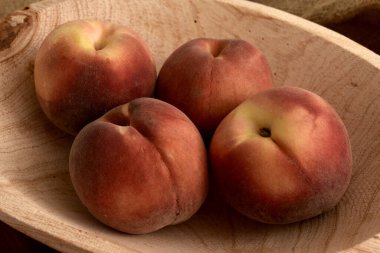 Tahta bir masada olgun şeftaliler