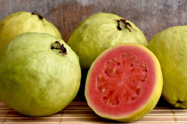 Tahta arka planda taze kırmızı guava meyvesi