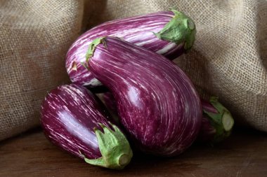 Tahta arka planda taze organik patlıcanlar.