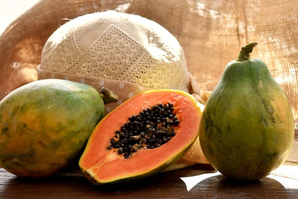 Fruta Mamão Uma Mesa Madeira Com Chapéu Palha Fundo Tecido — Fotografia de Stock