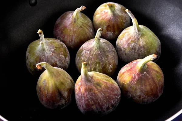 figs in a black plate on a dark background