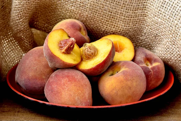 成熟的桃子放在木制底座的盘子上 — 图库照片