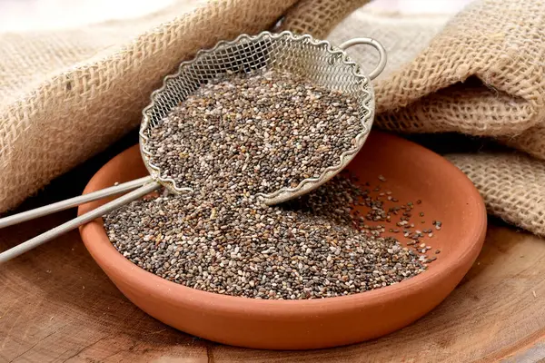 Tahta masadaki bir kasede chia tohumları