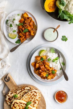 Vejetaryen, vejetaryen Hint körisi, karnabahar ve balkabağı yanında raita, naan ekmeği ve mango turşusu ve beyaz arka planda basmati pilavı.