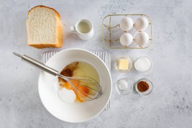 Minimal style flat lay of ingredients for making french toast (or wentelteefjes in Dutch) on white grey background, view from above, French Toast being prepared clipart