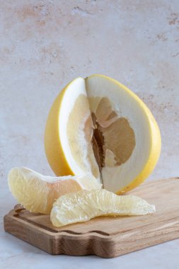 Lezzetli sarı bir çiçek dilimlenmiş ve tahta bir kesme tahtasının üzerinde bir bıçak tarafsız bir zemin üzerinde ağ torbası ile, fotokopi alanı ile dikey olarak.