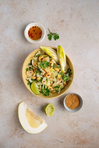 Hindiba, salatalık, kaju, kişniş, kavrulmuş hindistan cevizi ve soğuk limon soslu lezzetli vejetaryen usulü salata.