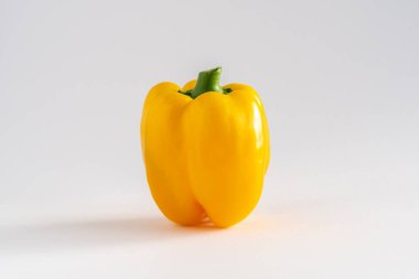 Beyaz zemin üzerinde tek bir sarı dolma biberin yakın plan fotokopi alanı, yatay