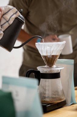 V60 kahve hazırlamak, kahveye sıcak su dökmek, kahve filtresi, kahve damlası.