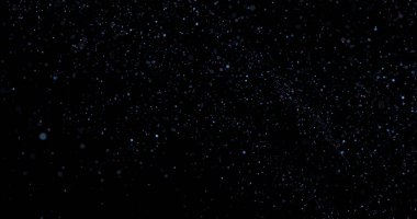 Siyah arkaplanda uçan toz parçacıkları