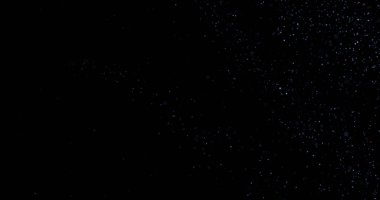 Siyah arkaplanda uçan toz parçacıkları