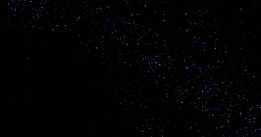 Siyah arkaplanda uçan toz parçacıkları