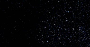 Siyah arkaplanda uçan toz parçacıkları