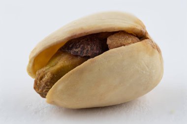 Beyaz arka planda izole edilmiş bir fıstığın makro görüntüsünü kapat