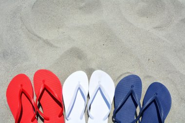 Flip flop senin metin için yer kum bol üzerinde kırmızı beyaz ve mavi