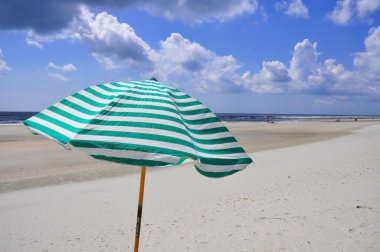 Deniz sahilinde plaj şemsiyesi