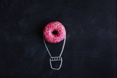 Balon şeklinde yaratıcı konsept donut, kara karatahtaya tebeşirle çizilmiş. Tatlı, çörek günü, pembe şekerleme, hamur işi, diyet, kalori, abur cubur, şeker..