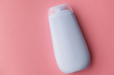 Pembe arka planda bir şişe duş jeli. Seçici odaklanma..