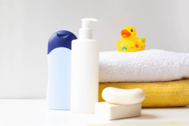Işık arka planında banyo yapmak için bebek aksesuarları. çocuğu yıkamak için. Bebek bakımı, duş jeli, bebek şampuanı, plastik ördek, seçici odaklanma..